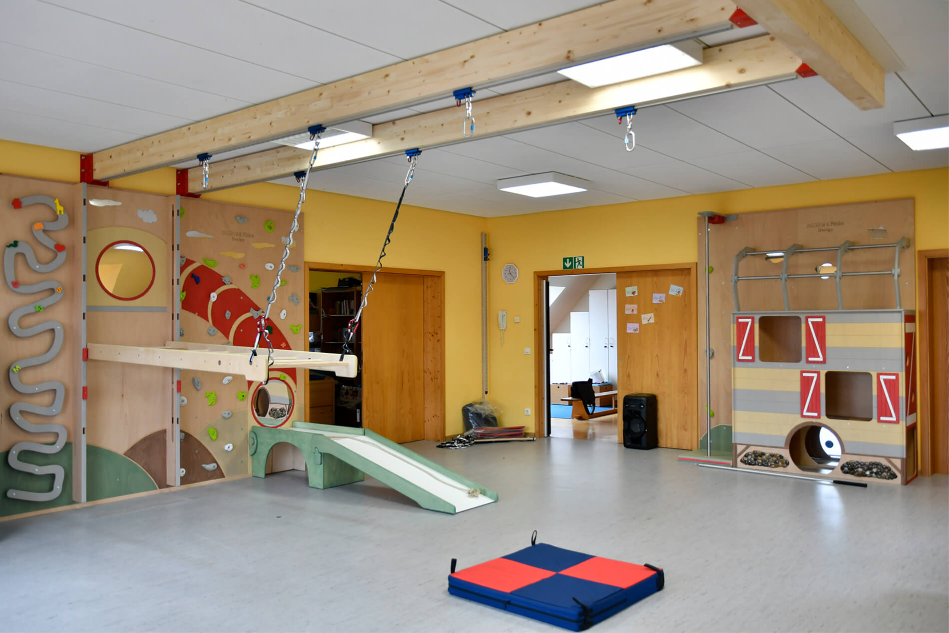 Bewegungsraum-mit-Kletterwand-und-Karussellschaukel
